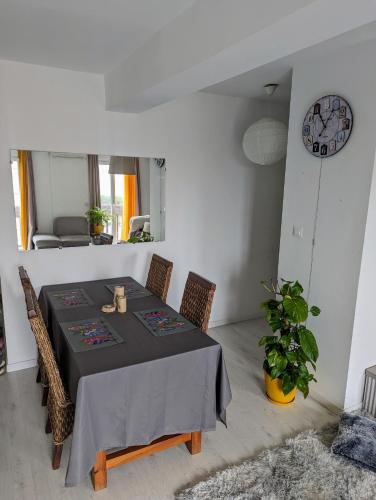 une salle à manger avec une table, des chaises et une horloge dans l'établissement Appartement cocooning, à Perpignan
