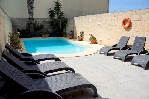 a group of chairs sitting next to a swimming pool at Casa Sammy in Sannat