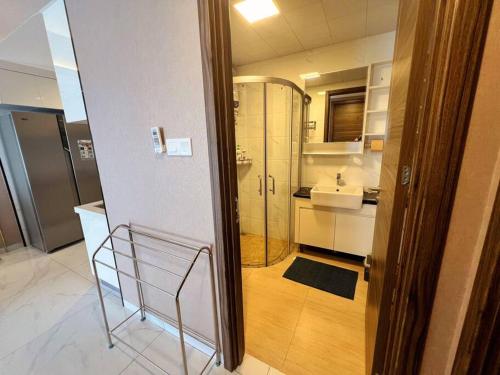 La salle de bains est pourvue d'une douche en verre et d'un lavabo. dans l'établissement Sky House BSD Apartemen T.Duxton, à Tjilandak