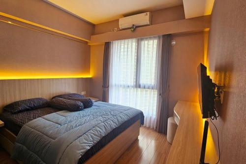 a small bedroom with a bed and a window at Sky House BSD Apartemen T.Duxton in Tjilandak