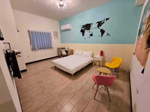 馬公市にある澎湖紙飛機民宿Paper Jet B&Bのベッド1台、椅子2脚、テーブルが備わる客室です。