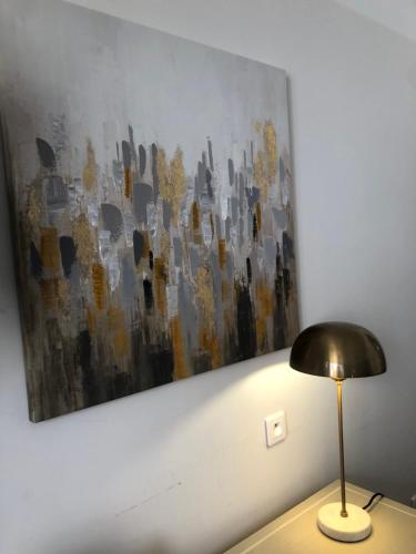 a painting hanging on a wall next to a lamp at Hotel Les Embruns in Le Touquet-Paris-Plage