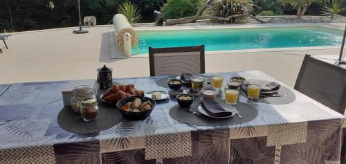 - une table avec une assiette de nourriture et de boissons dans l'établissement Domaine du Grézal, à Sarlat-la-Canéda