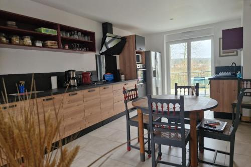 une cuisine et une salle à manger avec une table et des chaises dans l'établissement Chez la Mouzotte, à Domèvre-sur-Vezouze