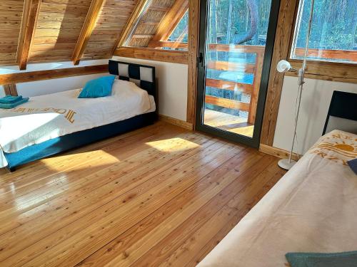 ZawadyCentrum Szkoleniowo-Wypoczynkowe Słoneczny Brzeg的一间卧室，有两张床和木地板