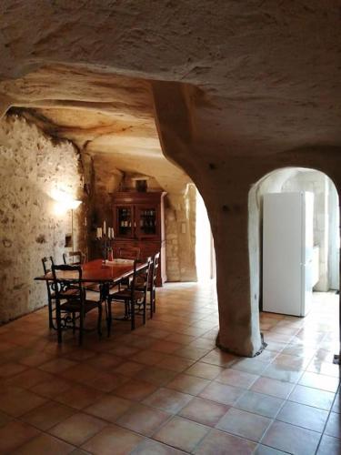 une salle à manger avec une table et des chaises dans l'établissement Maison atypique semi-troglodyte, à Chinon