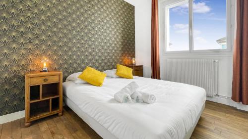 um quarto com uma cama com duas almofadas em HOMEY COLOC GATSBY - New, parking gratuit, proche gare, Balcons privés, Établissement élégant et moderne em Ville-la-Grand