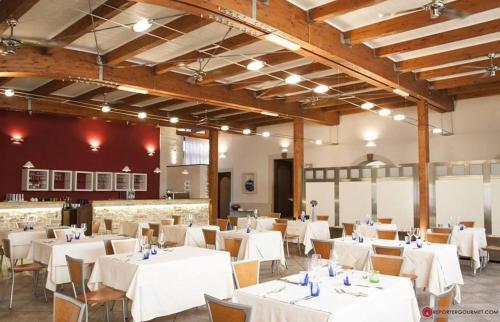 a dining room with white tables and chairs at Hotel Moderno in SantʼAntìoco