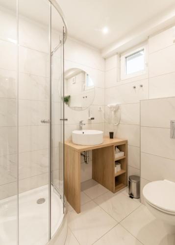a bathroom with a shower and a sink and a toilet at Ugo Apartman in Halászi