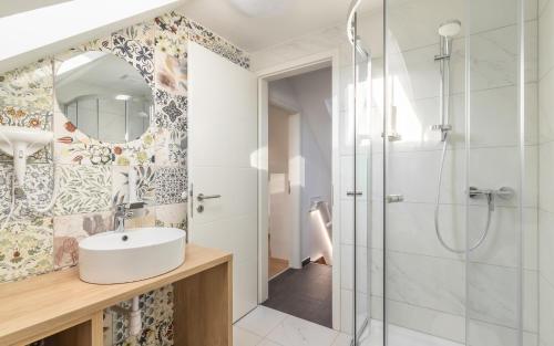 ein Badezimmer mit Waschbecken und Dusche in der Unterkunft Ugo Apartman in Halászi