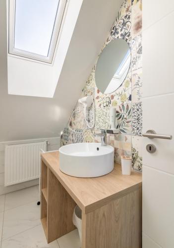 a bathroom with a sink and a mirror at Ugo Apartman in Halászi