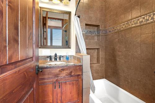 y baño con lavabo, bañera y espejo. en Arc de Texas -Louis XIV Suite en Johnson City