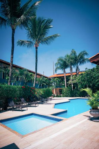 a swimming pool with palm trees in a resort at Ayla Praia Hotel Centro Porto Segur in Porto Seguro