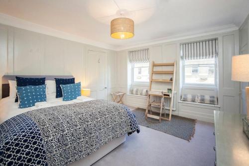 a bedroom with a bed with blue and white pillows at Elegant Georgian Maisonette - Central Bath in Bath