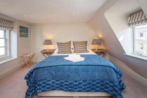 a bedroom with a blue bed with two pillows at Elegant Georgian Maisonette - Central Bath in Bath