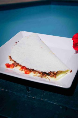 a white plate with a piece of food on it at Ayla Praia Hotel Centro Porto Segur in Porto Seguro