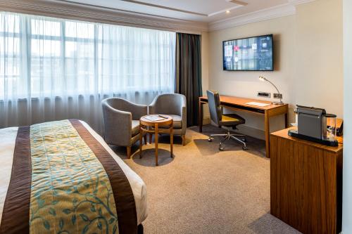 a hotel room with a bed and a desk and a computer at The Marble Arch Hotel, by Thistle in London