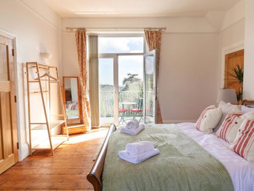 a bedroom with a bed with two towels on it at Red House in Lyme Regis