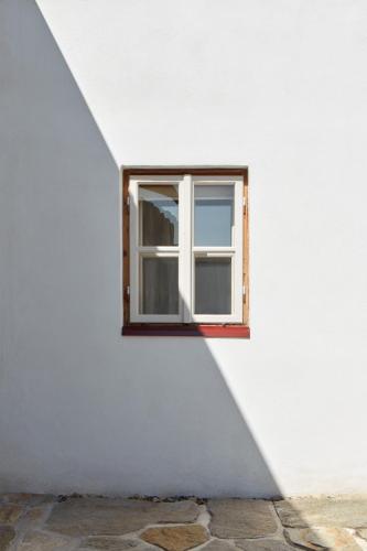 a window in a white wall with a shadow at Stará Pekárna/Old Bakery in Znojmo