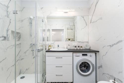 La salle de bains est pourvue d'un lave-linge et d'un lavabo. dans l'établissement Apartament Grzybowska 85 Premium by Your Freedom, à Varsovie