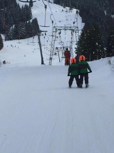 three people standing in the snow near a ski lift at Bed & Breakfast Jungholz - Pension Katharina in Jungholz