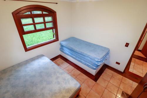 a room with two beds and a window at LINDA Chácara - IBIÚNA - Condomínio in Ibiúna