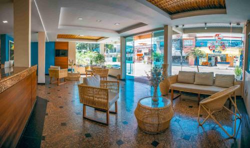 a lobby with a couch and a table and chairs at Ayla Praia Hotel in Porto Seguro