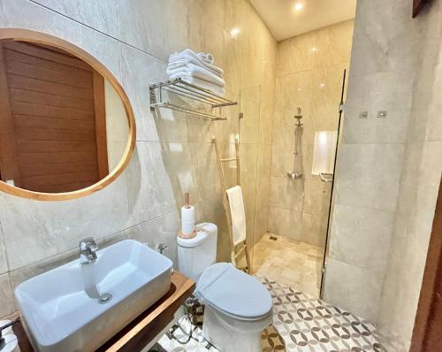 a bathroom with a sink and a toilet and a shower at Livin Sanur Villa in Denpasar