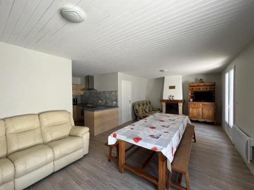 un salon avec une table et un canapé dans l'établissement Vacances reposantes a Oleron, au Château-dʼOléron