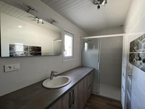 a bathroom with a sink and a mirror and a shower at Maison typiquement oléronnaise in Le Château-dʼOléron