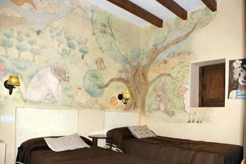 um quarto com um mural de uma árvore e duas camas em 6 bedrooms villa with private pool enclosed garden and wifi at Villanueva del Trabuco em Villanueva del Trabuco
