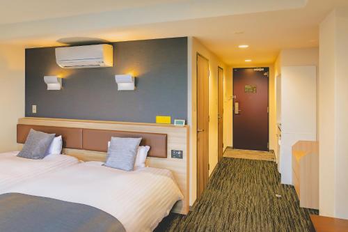 a hotel room with a bed and a hallway at AIRAIKUHOTEL kagoshima in Aira