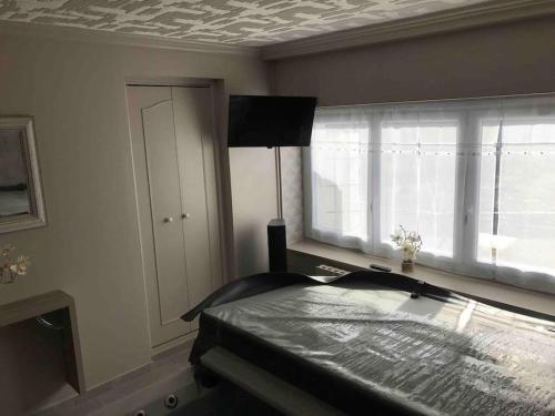 una camera da letto con un letto e una finestra di MAISON AVEC JACUZZI PRIVATIF a Cambrai