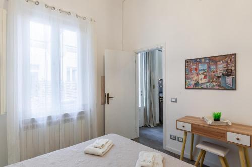 a bedroom with a bed and a desk and a window at La casetta del mare in Viareggio