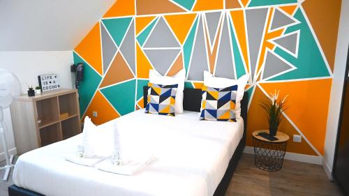 una camera con letto e testiera colorata di COCOONING Appartement 10mn Aeroport Roissy CDG a Villeneuve-sous-Dammartin
