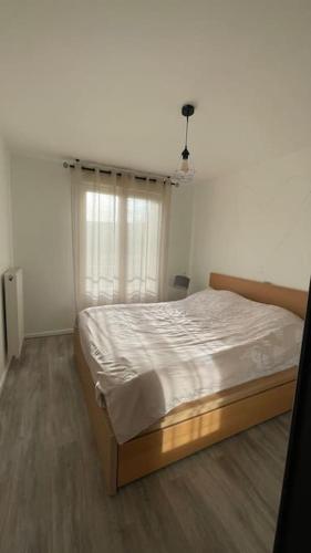 une chambre avec un lit dans une pièce avec une fenêtre dans l'établissement Appartement entier Paris/Disney, à Champs-sur-Marne