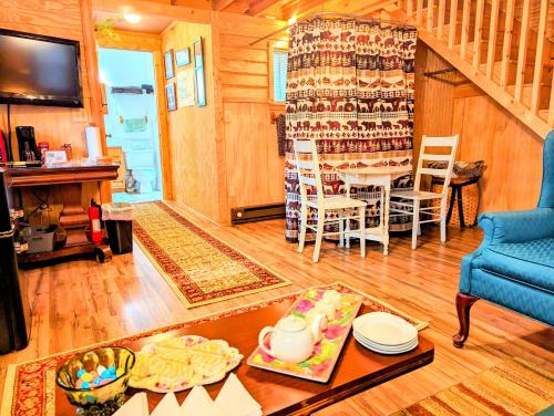 ein Wohnzimmer mit einem Tisch und einem Esszimmer in der Unterkunft Hidden Hollow Bed and Breakfast in Otto