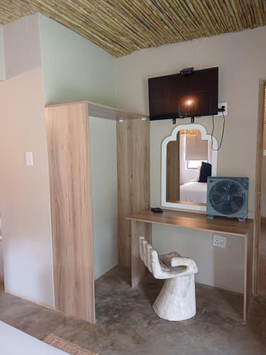 a bedroom with a desk with a mirror and a bed at Shangrila-innibos Country Lodge in Hartbeespoort