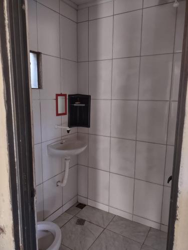 a bathroom with a toilet and a sink at KIT JARDIM CRISTAL in Aparecida de Goiania