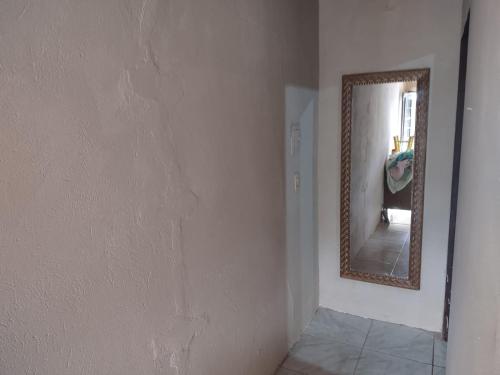 a room with a mirror on the wall and a hallway at KIT JARDIM CRISTAL in Aparecida de Goiania