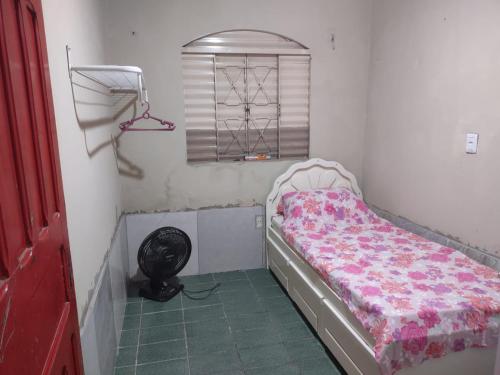 a small bedroom with a bed and a window at KIT JARDIM CRISTAL in Aparecida de Goiania
