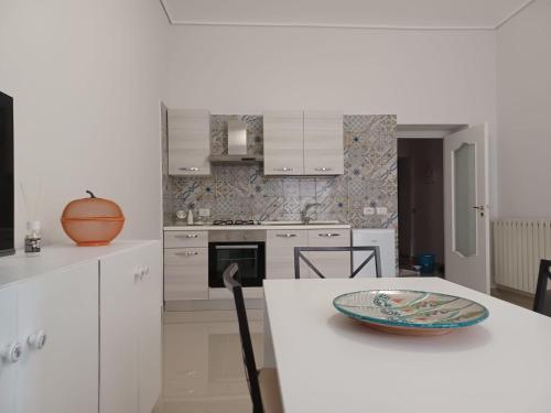 una cocina con armarios blancos y un bol en una encimera en Jolie, en Castellammare di Stabia