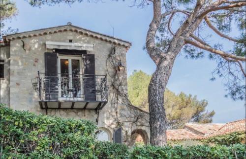 une maison en pierre avec un balcon et un arbre dans l'établissement Cap d’Antibes Sea view villa, à Antibes