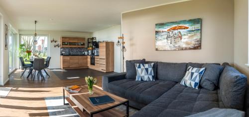 a living room with a couch and a table at Hangar 19 Luxusbungalow am See H8 in Schwerin