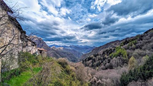 a valley in the mountains under a cloudy sky at B&B Piccolo Tibet in Lavenone