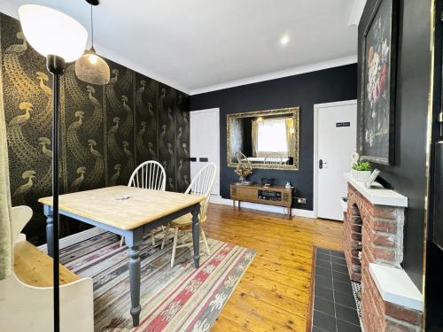 a dining room with black walls and a table and chairs at Stylish and Cosy stay in the Heart of Malton in Malton