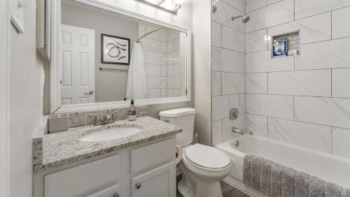 uma casa de banho branca com um lavatório e um WC em Landing at eXchange - 2 Bedrooms in Downtown Detroit em Detroit