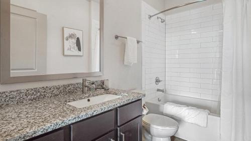 a white bathroom with a sink and a toilet at Landing at eXchange - 1 Bedroom in Downtown Detroit in Detroit
