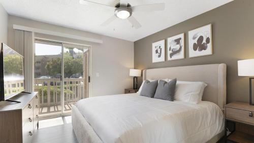 a bedroom with a white bed and a balcony at Landing at Bartram Park - 3 Bedrooms in Southside in Jacksonville