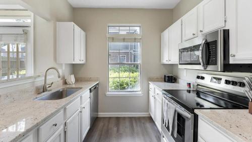 een keuken met witte kasten en een wastafel bij Landing at Bartram Park - 3 Bedrooms in Southside in Jacksonville